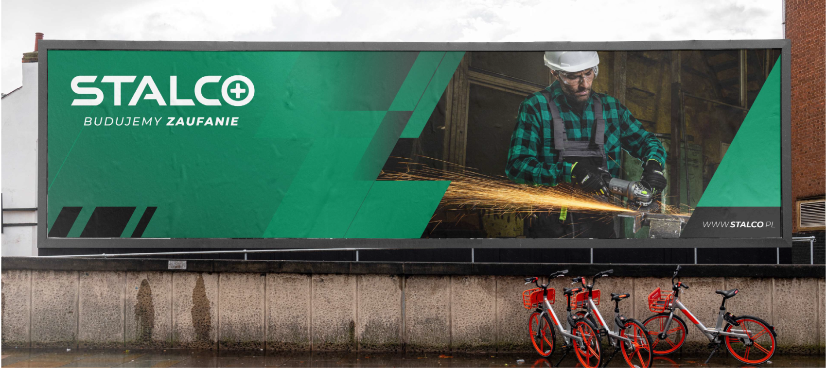 A big Stalco banner on the street. On the banner a construction worker is using a heavy duty machine